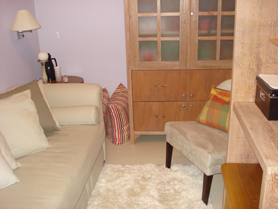 Sala de psicoterapia equipada com divã, espelho e ar condicionado, além do material para atendimento.
